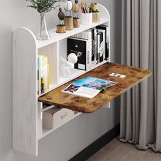 a wooden table sitting in front of a white book shelf filled with books and magazines