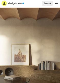 a room with a table, books and pictures on the wall next to each other