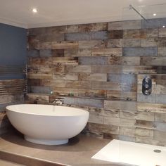 a large white bath tub sitting next to a wooden wall