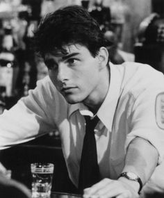 black and white photograph of a man leaning on a bar with his hand on the table