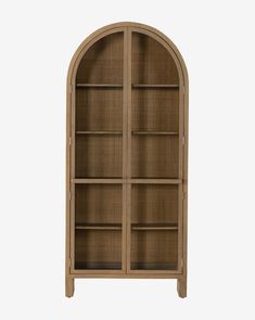 an arched wooden bookcase with glass doors and shelves on both sides, in front of a white background