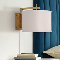 a lamp that is on top of a table next to some books and a pillow