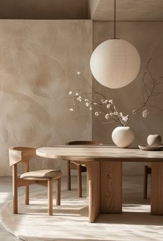 a wooden table with two chairs and a vase on top of it in front of a wall