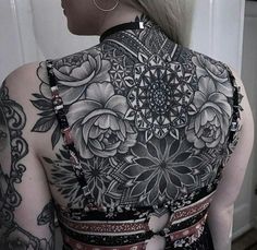 the back of a woman's body with tattoos on it