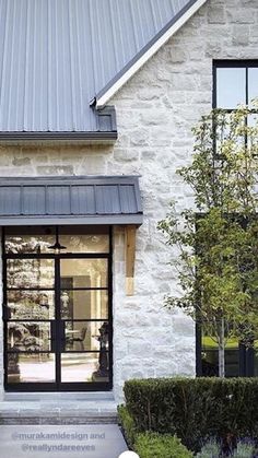 a white brick house with black trim and windows