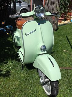 a green scooter is parked in the grass