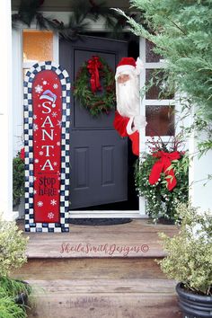 a santa sign sitting on the front steps of a house