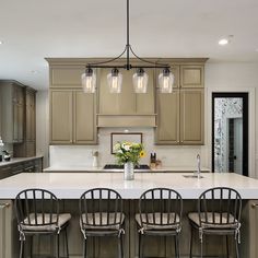 a kitchen island with four chairs around it