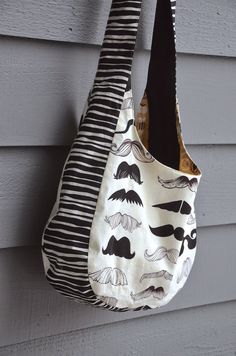 two purses hanging on the side of a house, one with moustaches