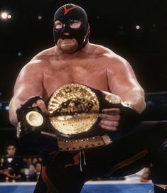 an image of a man holding a wrestling ring in his hands and wearing a mask