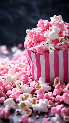 a pink and white striped cup filled with popcorn