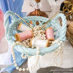 a basket filled with beads and spools of thread on top of a table