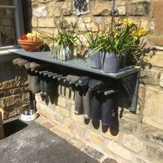 there is a shelf with some flowers and rain boots hanging from it's sides