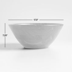 a large white bowl sitting on top of a table next to a measuring line with the measurements