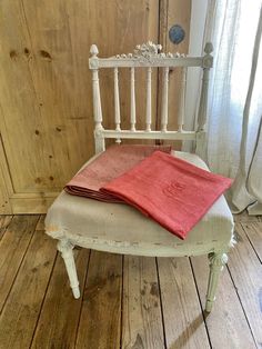 a stack of folded towels sitting on top of a white chair