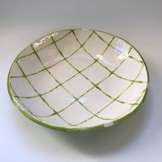 a green and white bowl sitting on top of a table