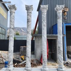 four white marble pillars in front of a building