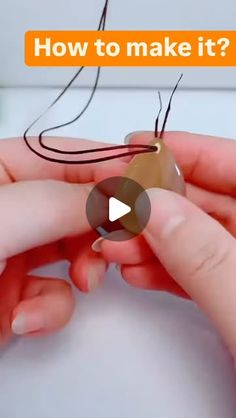 someone is making something that looks like an ornament with string and thread on it