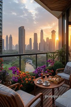 a balcony with two chairs and a table on it, overlooking a cityscape