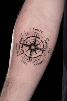 a man's arm with a compass tattoo on it