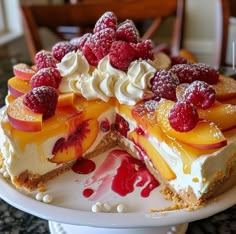 there is a cake with fruit on top and white frosting in the middle, ready to be eaten