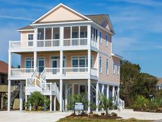 a large white house sitting on top of a sandy beach