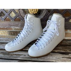 a pair of white shoes sitting on top of a wooden bench