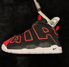 SneakerHead Covers are upcycled or new kid's sneakers that fit your putter! We're sourcing the best from Jordan, Yeezy, Nike and others to bring your sneaker game to the course.  For blade style or mid-mallet style putters only. Sale is for 1 shoe. No custom work on this one since no laces to tuck. Just a clean shoe ready to slip over your putter.  Nike Air Uptempo "Red Toe" (Brand new shoe) Black Low-top Golf Sneakers, Nike Air Uptempo, Putter Cover, Jordan Yeezy, Golf Putter, Golf Putters, Sneaker Games, Clean Shoes, Outdoor Games