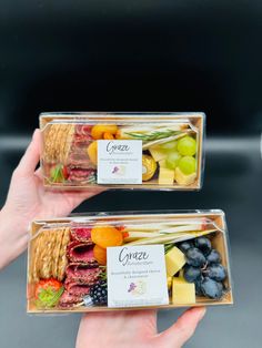 two plastic containers filled with different types of fruit and crackers on top of each other