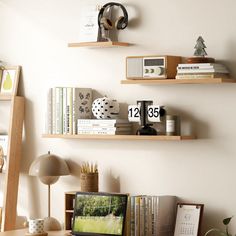 two wooden shelves on the wall above a desk with a laptop and other office supplies