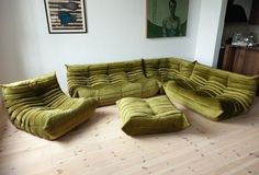 a large green couch sitting on top of a hard wood floor