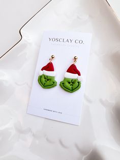 Grinch polymer clay earrings. Perfect for Christmas events.  -Handmade polymer clay earrings -Extremely lightweight.  -Posts are 24 K gold plated stainless steel. Nickel-free. Hypoallergenic. -Rubber silicone backs.  Every piece is handmade with love by me. Although I try to make them as identical as possible, none will be exactly the same. There might be some slight differences in color, shape, or texture. There might also be differences due to lighting. Please handle polymer clay earrings with care. Store them in a cool, dry area like a box or separate place to avoid scratches.  Do not shower, bath or swim with your earrings. To clean them you can use a soft damp cloth with mild dish soap.  Avoid any contact with perfume, oils, or chemicals. Christmas Ornament Earrings, Grinch Polymer Clay, Grinch Earrings, Seasons Activities, Polymer Clay Christmas, Christmas Events, Earrings Christmas, Holiday Earring, Grinch Christmas