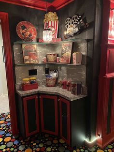 a kitchen area with red cabinets, black walls and polka dot flooring on the floor