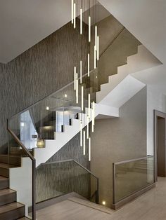 an elegant staircase with chandelier and glass balconies in a modern home