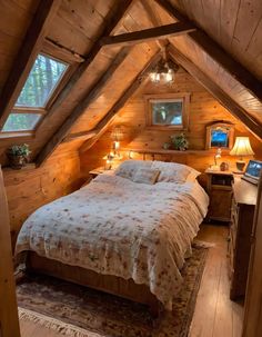 a bed in a room with wooden walls and ceiling beams, along with two lamps on either side of the bed