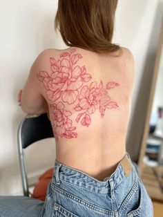 the back of a woman's shoulder with pink flowers on her left arm and chest