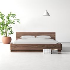 a bed sitting next to a potted plant on top of a white floor