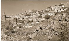 an old black and white photo of houses on a hill