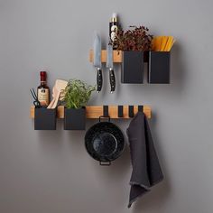 a kitchen shelf with pots and pans hanging from it's hooks on the wall