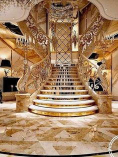 an elegant staircase with marble steps and chandelier in a luxurious house or hotel