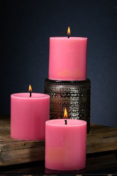 three pink candles sitting next to each other