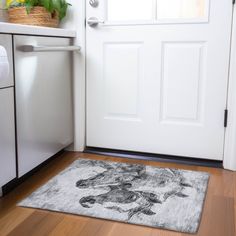 a door mat with a dog on it in front of a white door and dishwasher