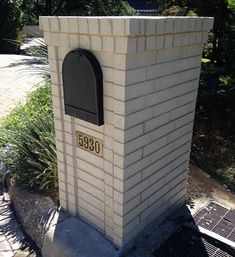 a brick mailbox sitting on the side of a road