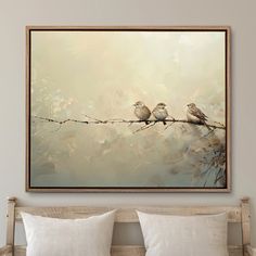 two birds sitting on a branch in front of a painting