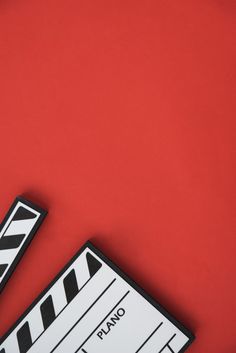 a close up of a movie clapper on a red background with space for text