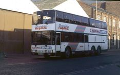 a double decker bus is parked on the side of the road in front of some buildings