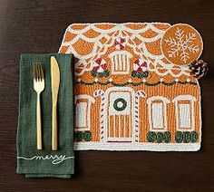 a place mat with a house on it and a fork next to the napkins