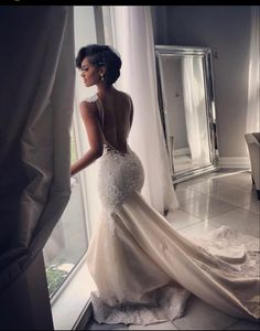 a woman in a wedding dress looking out the window