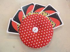 four red and white polka dot covered buttons on a wall with stickers attached to them