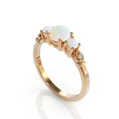 Unique Opal Engagement Ring 3 opal ring Promise ring opal women ring Retro Art Deco Diamond Wedding ring White Opal Jewelry Anniversary Gift natural 3 opal White engagement ring with lovely diamonds, set in 14k solid gold. ► FEATURES; Gemstones: Center natural white opal 5.5mm : 2 lovley 3mm small opal Diamond: Total carat weight: 0.03 (Color H; clarity VS) Material options: 14k rose gold, 14k yellow gold, 14k white gold Size: all ring sizes are available How to Order: Please select your preferr Elegant Opal Cabochon Ring, Elegant Pink Opal Moonstone Ring, Elegant Ethiopian Opal Ring For Anniversary, Elegant Ethiopian Opal Ring, Fine Jewelry Opal And Moonstone Multi-stone Ring, Opal And Moonstone Multi-stone Fine Jewelry Ring, Wedding Multi-stone Ring With Ethiopian Opal, Wedding Opal Cabochon Ring In Fine Jewelry Style, Fine Jewelry Wedding Opal Cabochon Ring